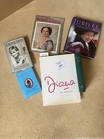 Photo showing six books about the British Royal Family arranged on carpet, including a signed copy of 'A Royal Duty' by Paul Burrell.