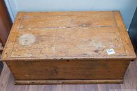 Top view of oak chest showing scratches, chips, cracks, and a white stain on the lid surface