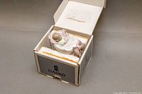 Figurine inside the open LLADRO box showing its packing material and partial wrapping.