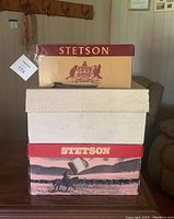 Three stacked Stetson branded boxes, two cream-colored and one brown/tan box with logo and cowboy artwork.