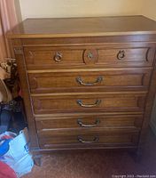 Front view of the vintage Thomasville dresser showing five drawers and brass hardware handles.
