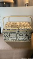 Front view of the large fabric covered sewing box with tribal pattern and raised fabric handle.