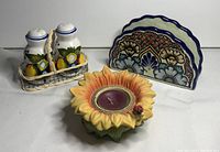 Full view of all items in the lot, showing the candle holder, salt and pepper shakers in wire basket, and napkin holder.