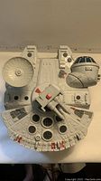 Top view of the Millennium Falcon toy showing detailed exterior, sensor dish, cockpit, and hull design.