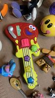 Close-up of Sesame Street toy guitar with Elmo face and bright colored buttons