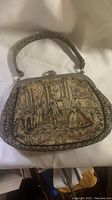 Front side of vintage La Marquise tapestry handbag showing detailed historical scene and woven handle.