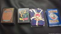 Four stacks of trading cards: Magic the Gathering, Dragonball Z, Pocket Monsters, and Pokemon backs visible.