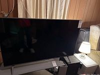 Front view of the LG TV showing the screen, stand, and a price tag.