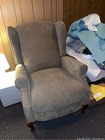 Front and angled view of the wingback chair showing upholstery pattern and shape.