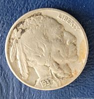 Obverse view of 1937 Buffalo nickel showing Native American profile and date 1937 clearly visible with some wear and discoloration.
