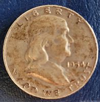 Obverse side of the 1954 Franklin half dollar coin showing Benjamin Franklin's profile, date 1954, and inscriptions.
