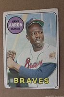 Front of 1969 Topps Hank Aaron baseball card showing player image, name, team (Atlanta Braves), position (Outfield), and notable wear including corner damage and off-center printing.