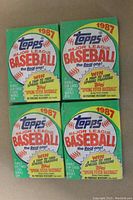 Front of four unopened 1987 Topps Major League Baseball wax packs showing green and white packaging with promotional contest text.