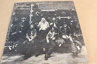 Front cover photo of The Allman Brothers Band album At Fillmore East showing band members posed together in black and white.