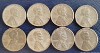 Obverse sides of the eight 1943 Lincoln Wheat steel pennies showing Abraham Lincoln's profile and the year 1943.