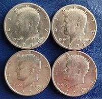 Obverse side of four Kennedy half dollars from 1971, 1972, 1973, and 1974, showing the profile of John F. Kennedy with date and inscriptions.
