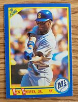 Front image of the 1990 Score baseball card showing Ken Griffey Jr. batting in a Mariners uniform with blue dot error in Mariners logo at bottom right.