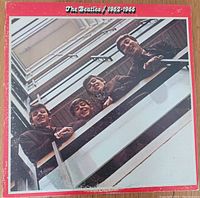 Front cover of The Beatles 1962-1966 double album with band on balcony photo and red border.