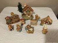 Full lot view showing 10 bunny figurines, one cottage house, and raft with barrel.