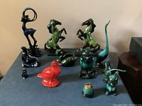 Full view of 12 Blue Mountain Pottery pieces including animals and decorative items in blue, green, red and black hues.