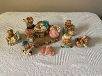 All ten bunny figurines arranged on display base and tablecloth, showing various poses and activities in pastel colors.