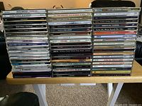Full front view of all 60 CDs stacked in three columns showing a wide range of music genres and artists.