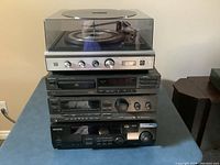 Stack of four stereo components showing front panels: Technics CD player and receiver, Kenwood receiver, and Sears turntable on top