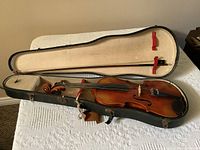 Violin and bow inside open hardshell case