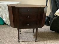 Front view of vintage Martha Washington sewing cabinet with flip-top sides closed.