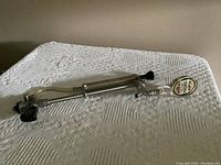 Metal beer tap handle with Youngers Tartan Special badge at the top, lying on a textured white cloth.