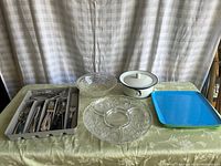 Overview of all items including silverware tray, pressed glass platter, Dansk ceramic bowl with lid, plastic trays on table