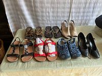Lot of 8 pairs of ladies shoes with variety of styles and colors shown on table