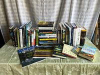 Overview of all books included in the lot, showing a mix of fiction and nonfiction titles, arranged on a table.