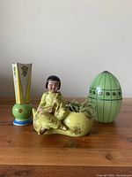 Photo shows all three vintage decor items together on a wooden surface: the MCM planter, green glass egg container, and art deco vase.