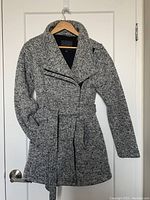 Full front photo of lightweight knit coat on hanger showing overall design, color, and belt.