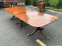 Full view of extended table outdoors showing all three pedestals and two leaves