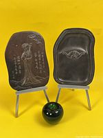Two inkstone slabs on metal stands with water dropper front and center