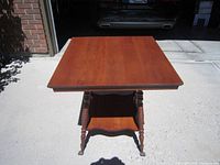 Front view of the antique claw foot table showing the top surface and turned legs with claw feet on casters.