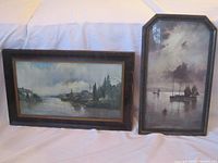 Both framed prints displayed on a white cloth background showing their overall appearance and condition.