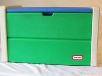 Side and front view of the Little Tykes toy chest showing green panels with a blue lid and beige sides, along with Little Tykes logo on front.