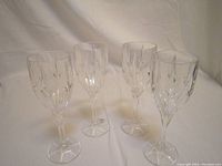 Four clear Lenox crystal wine glasses arranged in a group, showing the faceted cut design on the bowls and long stems.