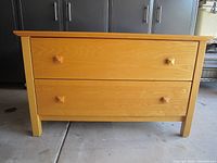 Front view of the dresser showing two drawers and wooden knobs.