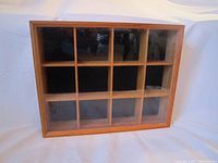 Front view of the oak display cabinet showing 12 compartments behind glass door.