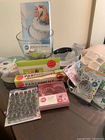Main lot items grouped on table showing Wilton baking supplies including parchment paper and cookie cutters.