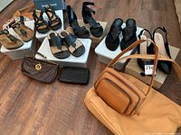 All shoes and purses together on floor including multiple sandals, heels, and purses