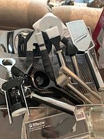Photo of kitchen utensils including corkscrew, garlic press, and more in wire basket