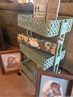Full view of the metal cart with all items on and around it, including framed pictures and plaques.