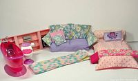 Full set of vintage Barbie sized doll furniture and accessories including bed, sofa, bathtub, toilet, sleeping bag, and entertainment cabinet seen together