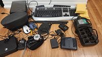 Overview of all electronics including camera, MP3 player, chargers, keyboard, mice, and router