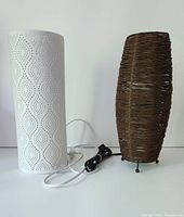 White and brown wicker lamps side by side with cords visible